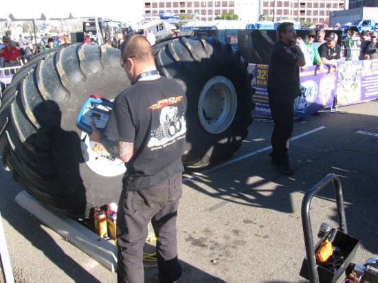 Mechanic guy near a couple of gigantic spare tires.