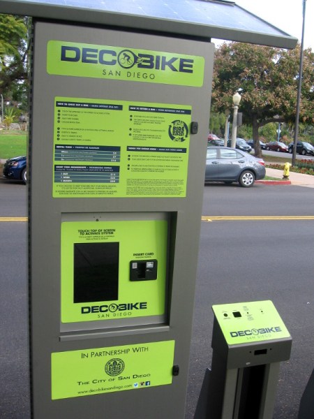 DecoBike bikeshare stations feature a touchscreen, instructions and a row of bike docks.