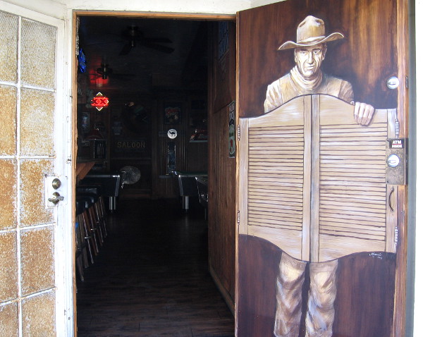 John Wayne seems to be coming through a door of the Old Town Saloon.