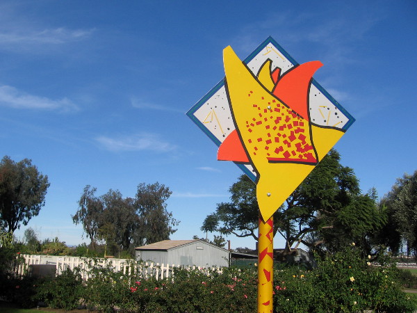 Odd, speckled sign stands beside Balboa Park's rose garden.