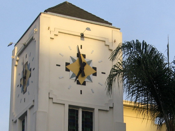 Eye-catching clock atop tower on a street corner.