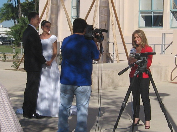 This soon-to-wed couple is interviewed by a television reporter.