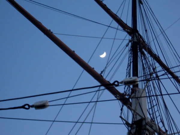 Moon behind a mast and yards of San Diego's historic 1863 bark Star of India.
