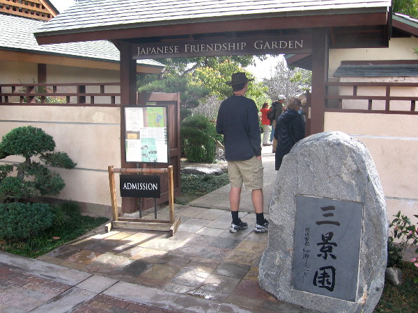 People enter Japanese Friendship Garden. The San-Kei-En entrance stone, gift from San Diego's sister city Yokohama, translates Three Scene Garden--Water, Pastoral and Mountain.