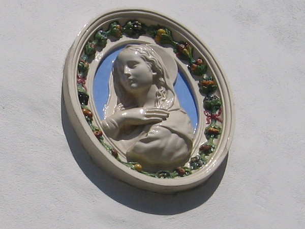 Medallion-like artwork on wall above the Italian Cultural Center sign.