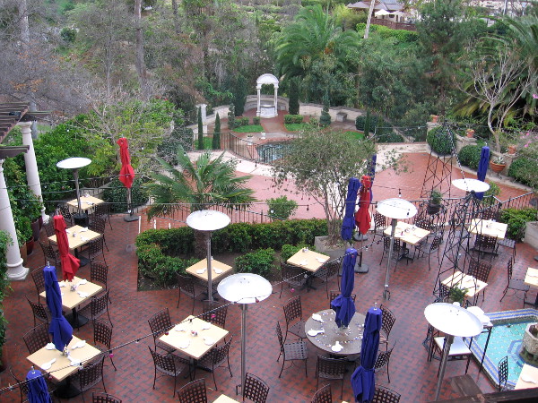 View from House of Hospitality balcony of The Prado restaurant's outdoor seating near the garden.