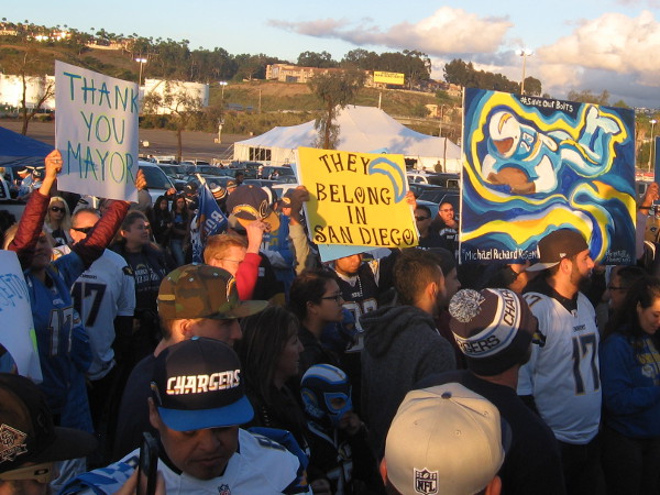 Handmade signs express hope that Chargers football remains in San Diego.