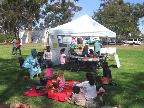 Kids listen to stories out in a patch of shade on a warm Spring day in San Diego.
