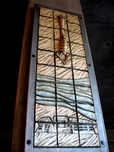 Spine rises over what I believe is Qualcomm Stadium. This earthy art is unusual and evocative.