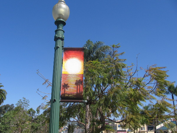 A typical beach scene with palm trees and setting sun.