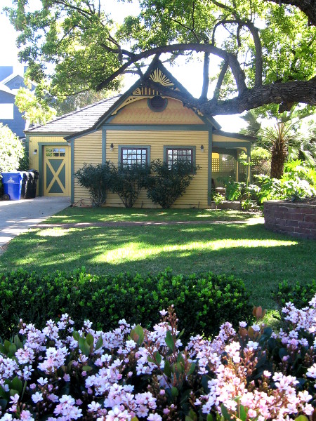 Nearby carriage house behind flowers.