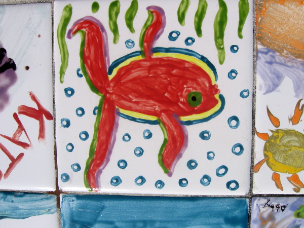 A red fish just swimming along in blue bubbles.