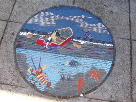 Tile mosaic on Pacific Coast Highway shows fisherman rowing out over the ocean.