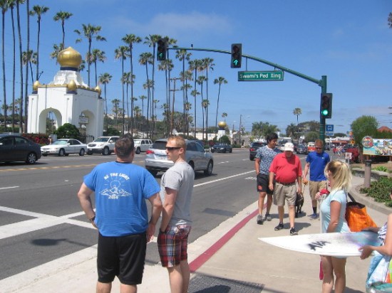 People wait at Swami's pedestrian crossing, with exotic golden domes of the Self-Realization Fellowship across PCH in the background.