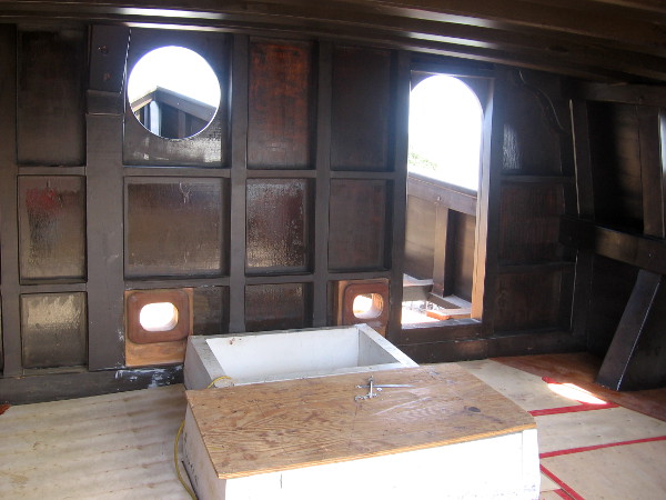 Under the forecastle, looking toward the bow's beak. The two holes beside the rectangular chain locker are hawseholes, through which the anchor chain is lifted or lowered.