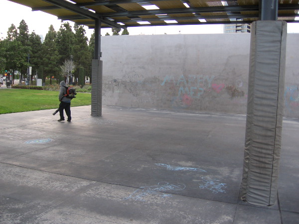 Guy cleaning the play area in the early morning with a noisy blower.