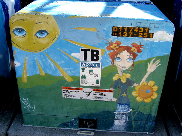 Flowers in hair, on shoulders. A golden star joins the sun and sunflower in symbolic street art.