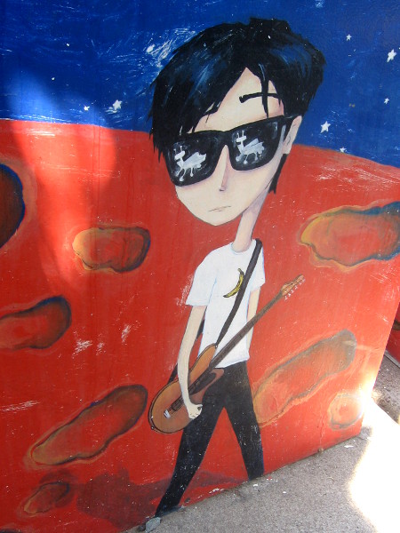 Musician in cool sunglasses plays guitar where he stands in the cosmos.