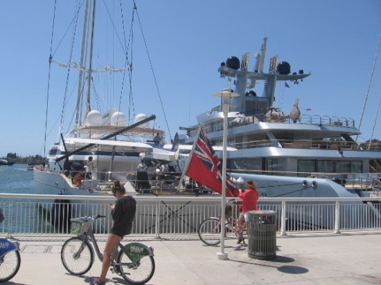 Two super yachts with small aircraft seen in April 2015. On the left, the enormous single-masted yacht M5 boasts a seaplane, while the Pacific carries a helicopter.
