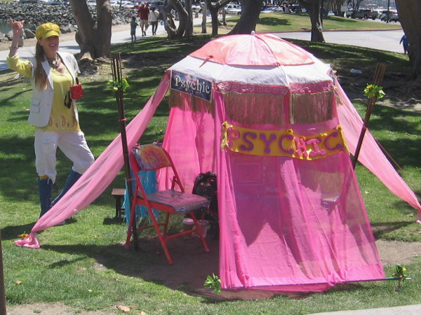 This smiling psychic has a bright pink tent!