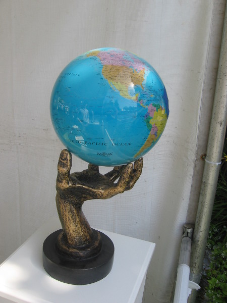 Solar-powered rotating globe held in a human hand.