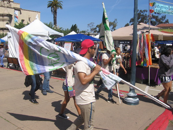 Some guys carry flags in preparation for a small Earth Day parade through Balboa Park.