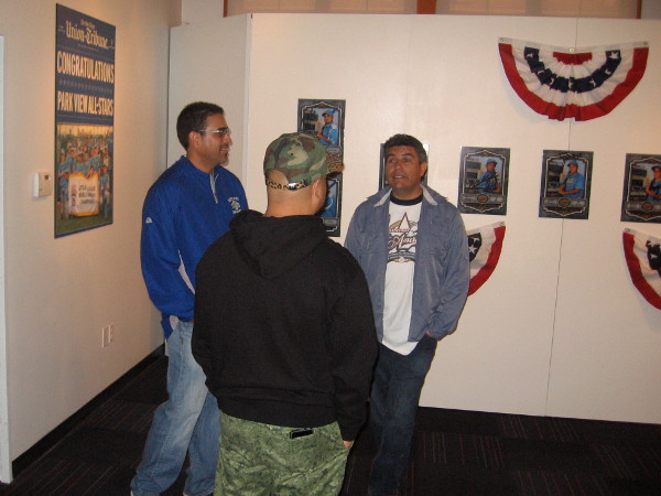 Park View Little League 2009 coach Ric Ramirez talks with visitors at cool New Americans Museum exhibit.
