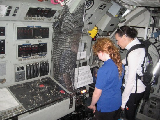 Folks peer down through floor at Pump Room below the Control Room, where a hero defied death to save his crewmates.