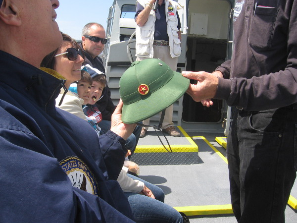 A pith military helmet once worn by Viet Cong soldiers is passed around for the passengers to examine.
