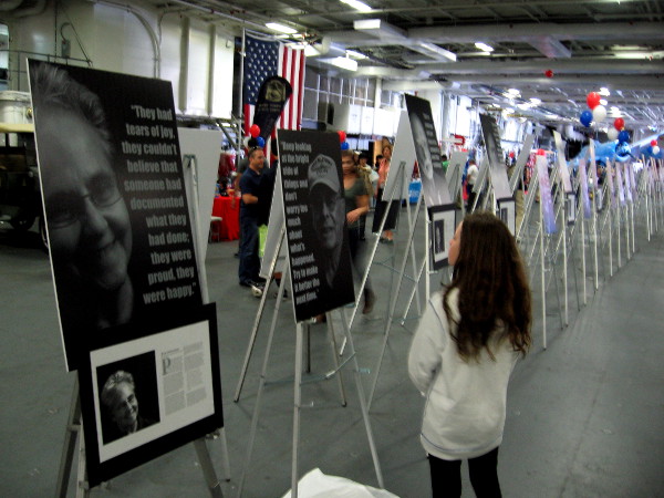Visitor to USS Midway Museum on Memorial Day weekend absorbs Portraits of Resilience exhibit, created by students of High Tech High Charter School.