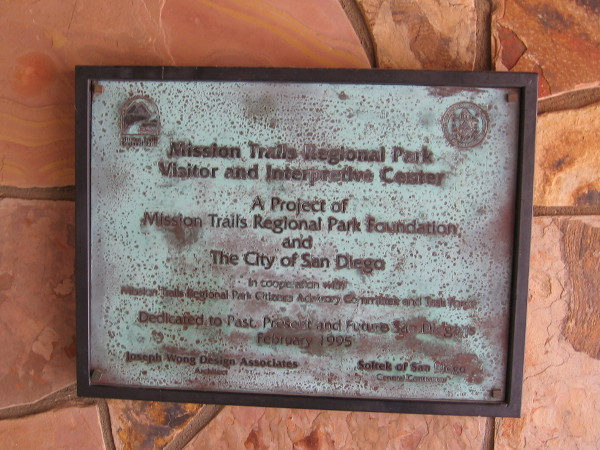 Plaque by door dedicates the large open space park to past, present and future San Diegans.