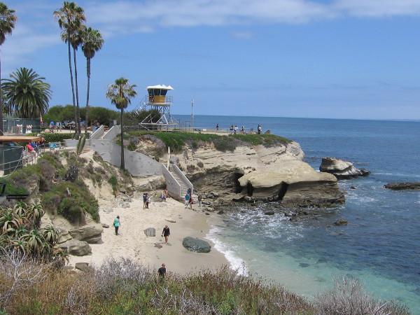 A lifeguard tower rises above La Jolla Cove Beach. To the right of the tower is Point La Jolla.