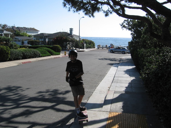 Kid skateboards down hilly Bird Rock Avenue toward the small lookout point.