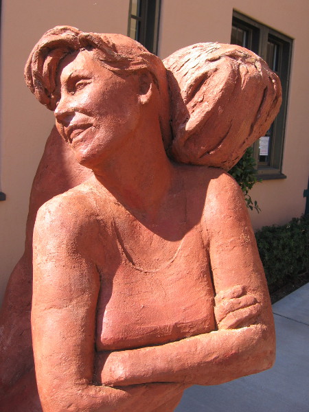 Light shines on Sisterhood terracotta sculpture, by artist Mary Buckman.