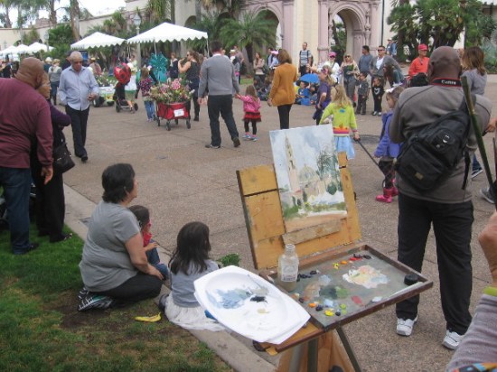 A painter in Balboa Park gets an eyeful as the parade passes by.