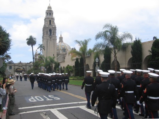 Proudly marching Marines head west down El Prado toward California Tower and Museum of Man.
