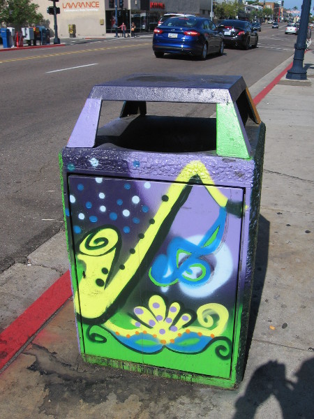 A big, joyful saxophone has been painted on this trashcan.