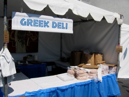 Pita bread is stacked up waiting at one end of this Greek Deli tent.