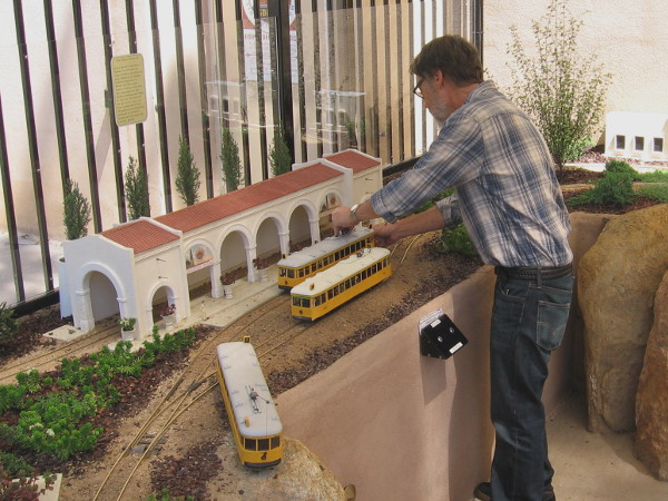 Putting a model of a streetcar on the tracks. A hundred years ago, John D. Spreckels' Class 1 streetcars provided transportation around San Diego.