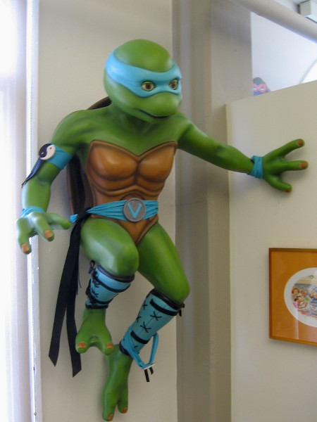Leonardo, wearing a blue mask, overlooks visitors to a room where kids and adults are encouraged to draw, experience and read about comic art.