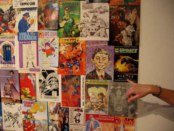 Past souvenir program covers feature many different superheroes and pop culture characters.