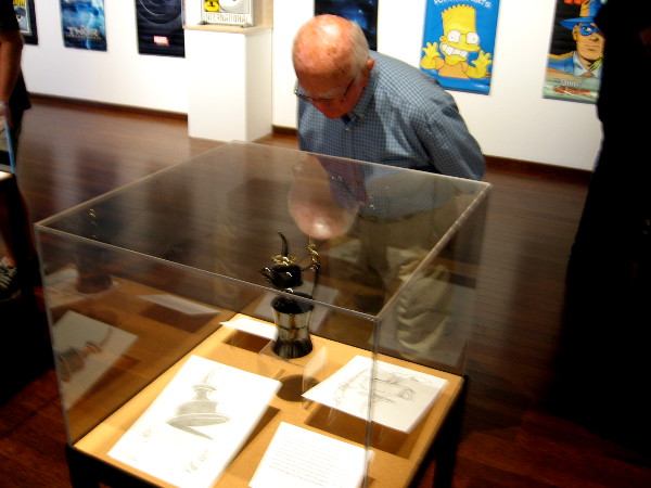 Someone checks out a display case containing an example of an Inkpot Award. These are presented to outstanding authors, artists and other creative luminaries every year during Comic-Con.
