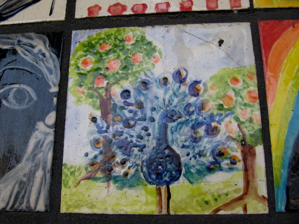 A blue peacock and two fruit trees.