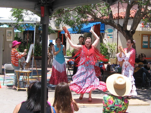 Crowd shouts and claps as the whirling ladies move their limbs and tap feet with graceful, fluid, precise abandon.