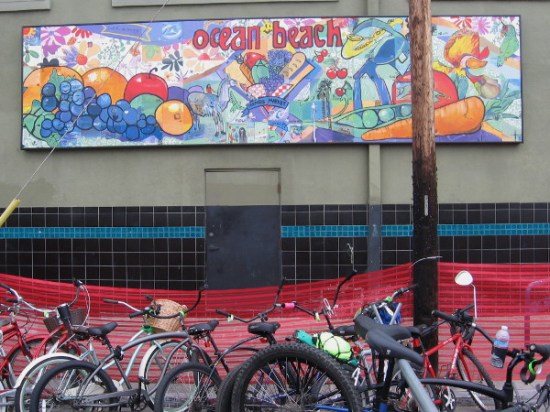 Another street mural on a wall above a station where people could park their bikes.