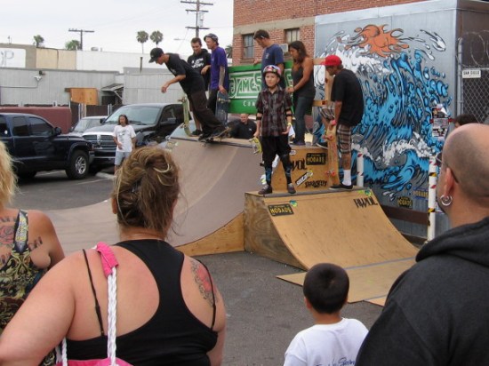 Lots of skilled skateboarders were taking turns on this small half-pipe.