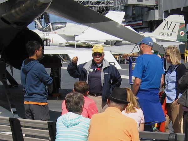 Docent veteran talks about how aircraft landed on the flight deck using tailhooks and arresting cables.