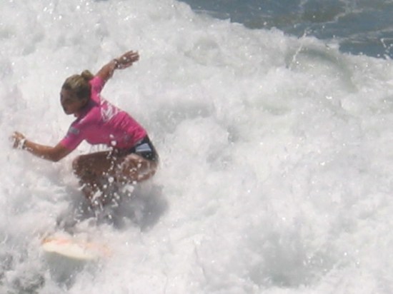 Professional World Surf League (WSF) Supergirl Pro Women's Qualifying Series surfer rides the foam in Oceanside, California.