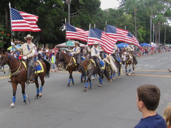 The Escondido Mounted Posse carry flags.