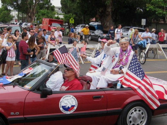 A Pearl Harbor survivor waves to a crowd. Many were shouting Thank You.